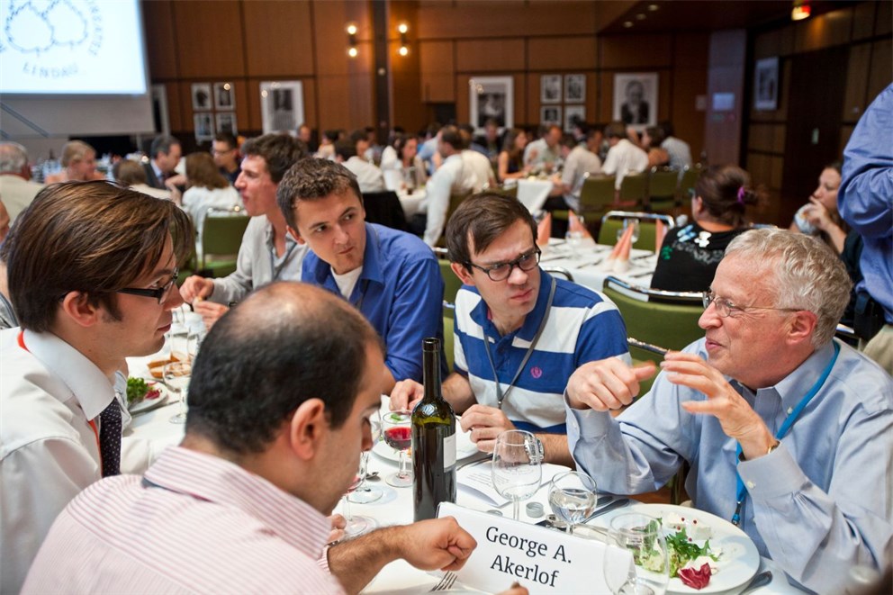 Nobel Laureate George Akerlof instructing young researchers at lunch break