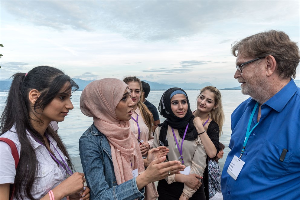 George Smoot talking to Syrian refugees at the social event Grill & Chill